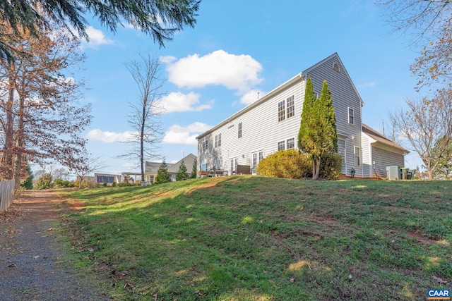 view of side of property featuring a lawn and fence