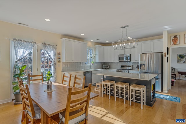 dining space featuring recessed lighting, visible vents, light wood-style flooring, and a toaster