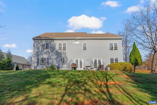 rear view of house featuring french doors, a patio, and a lawn