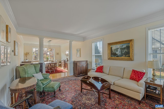 living room featuring decorative columns, a healthy amount of sunlight, and ornamental molding