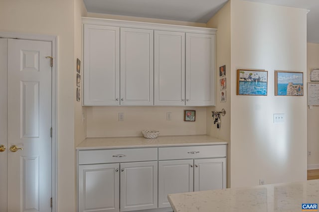 kitchen featuring light stone counters and white cabinets