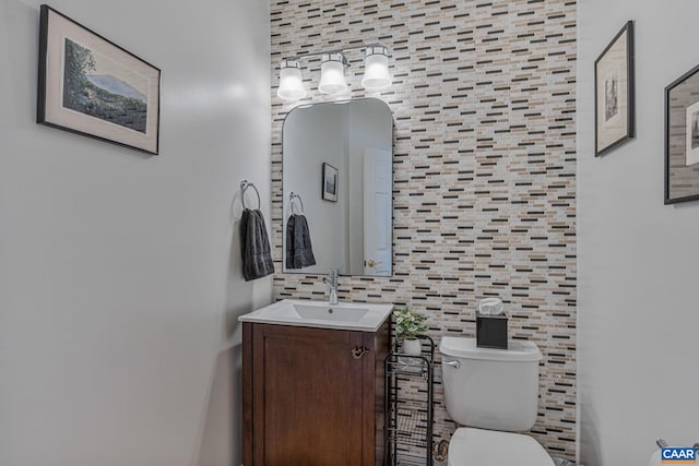 bathroom with vanity, tile walls, toilet, and backsplash