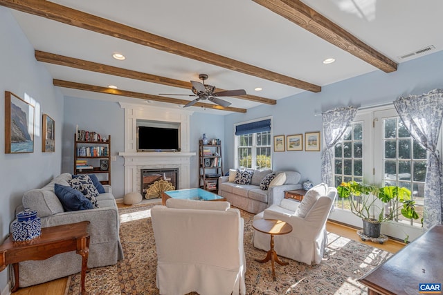 living room with recessed lighting, visible vents, wood finished floors, and a glass covered fireplace