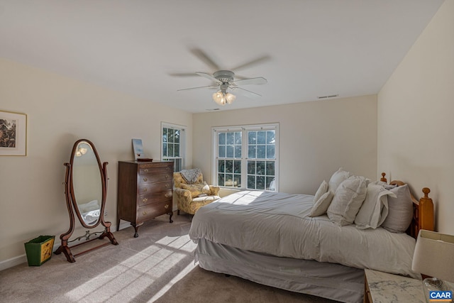 bedroom with a ceiling fan, light colored carpet, and visible vents