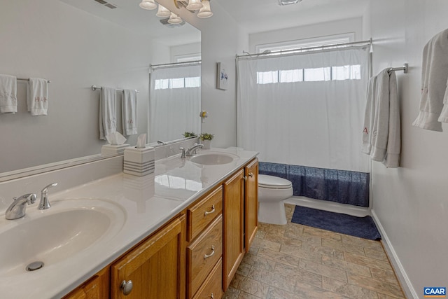 bathroom with toilet, plenty of natural light, and a sink