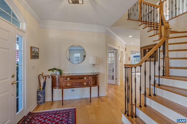 entrance foyer featuring stairway, ornamental molding, baseboards, and wood finished floors