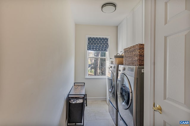 clothes washing area featuring cabinet space, baseboards, and washing machine and clothes dryer