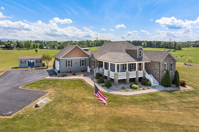view of front of home featuring stone siding, a garage, a porch, a front yard, and driveway