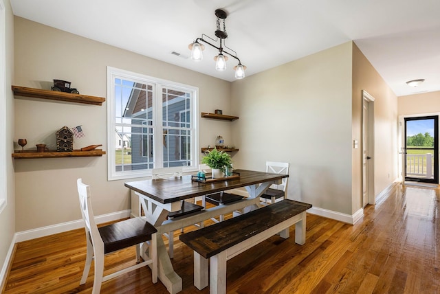 dining area featuring baseboards, light wood finished floors, and visible vents