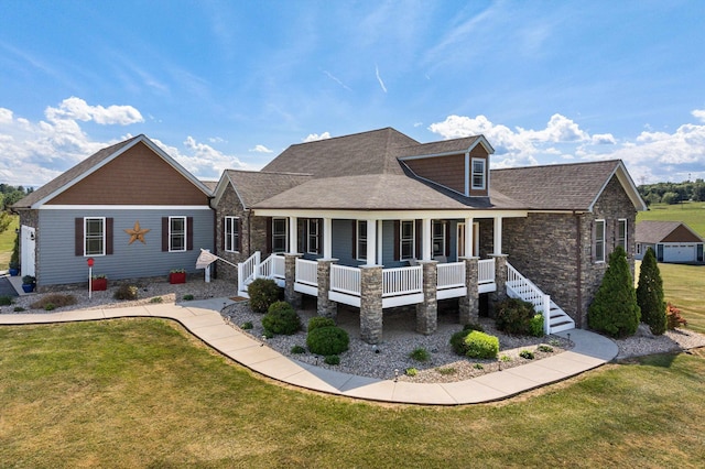 rear view of house with covered porch, a lawn, stairway, and roof with shingles