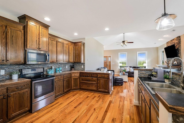 kitchen featuring dark countertops, appliances with stainless steel finishes, and open floor plan
