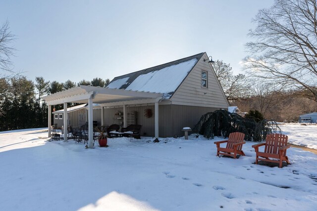 view of snowy exterior with a pergola