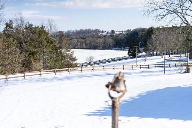 yard covered in snow with a rural view