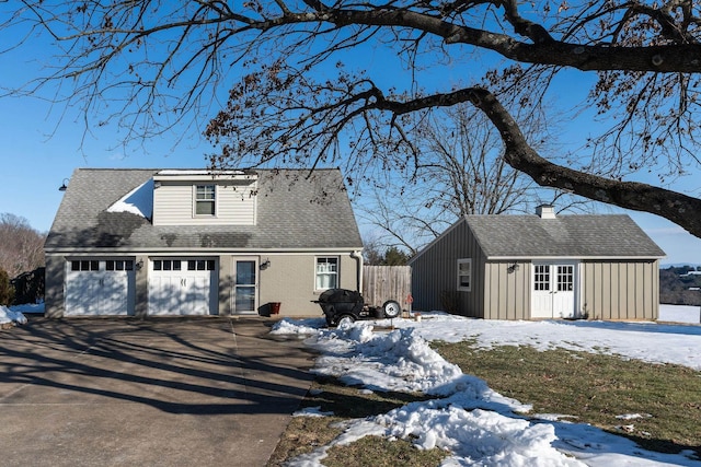 view of front of house featuring a garage and an outbuilding