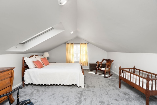 carpeted bedroom featuring vaulted ceiling with skylight