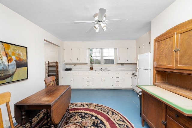 kitchen featuring ceiling fan, sink, white fridge, and white cabinets