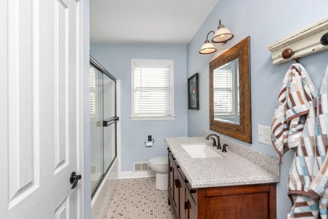 full bathroom featuring shower / bath combination with glass door, vanity, and toilet