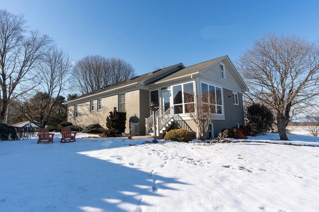 view of snow covered exterior featuring a sunroom