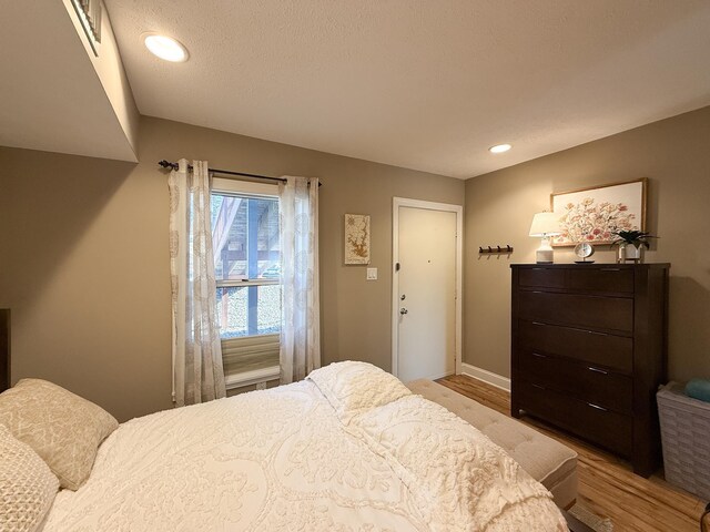 bedroom with light hardwood / wood-style flooring and a textured ceiling