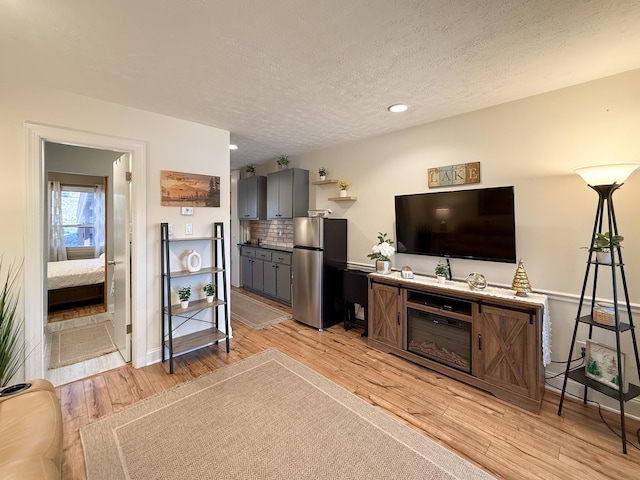 living room with a textured ceiling and light hardwood / wood-style floors