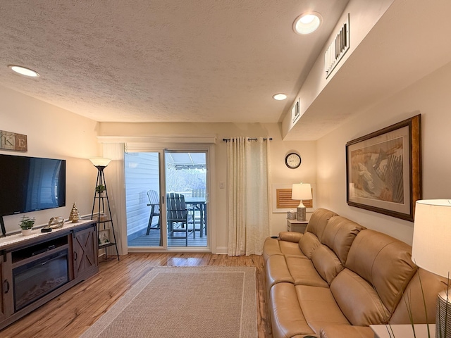 living room featuring a textured ceiling and light wood-type flooring