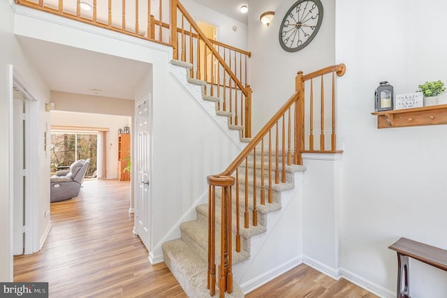 stairway featuring baseboards and wood finished floors