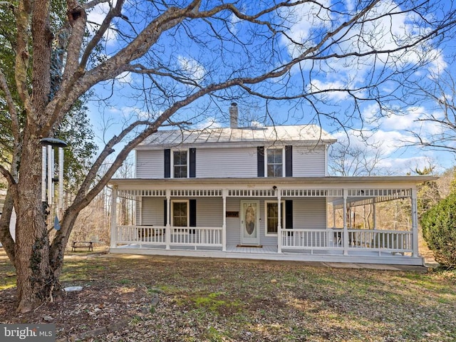 view of front of property featuring covered porch and a chimney