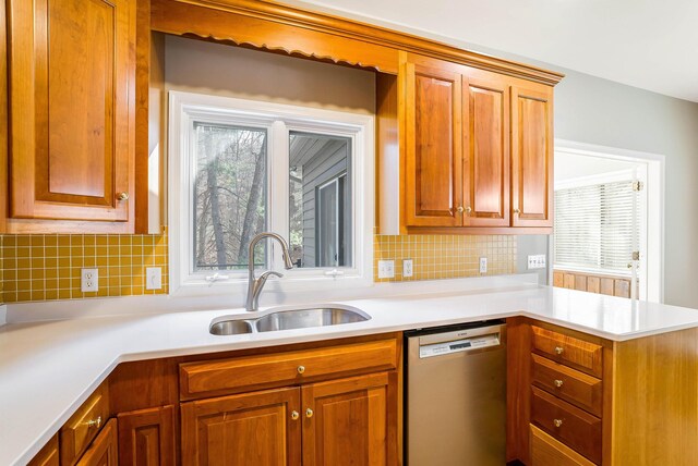 kitchen with sink, stainless steel dishwasher, and backsplash