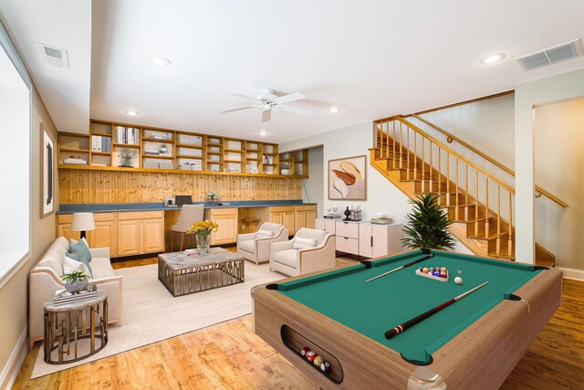 recreation room featuring ceiling fan, built in desk, and light wood-type flooring