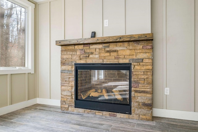 room details featuring a stone fireplace and hardwood / wood-style floors