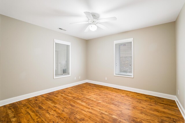 empty room with hardwood / wood-style flooring and ceiling fan