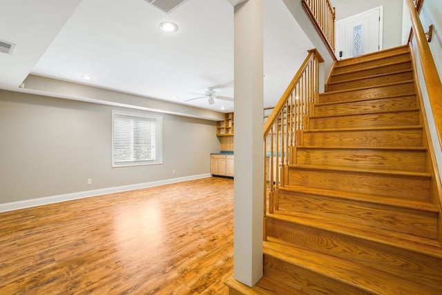 stairs with ceiling fan and wood-type flooring