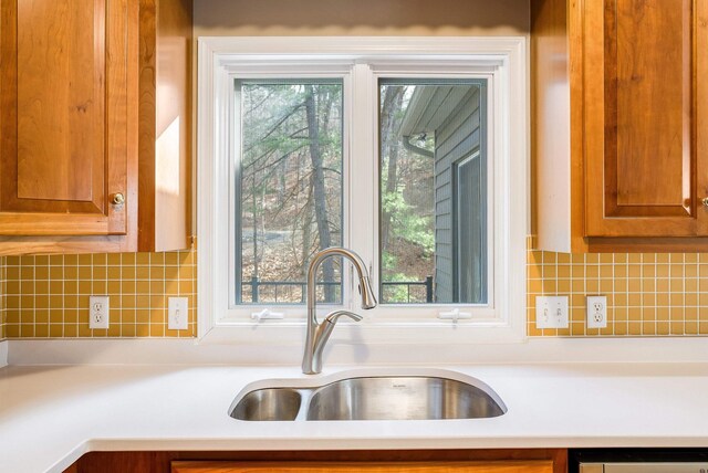 kitchen featuring tasteful backsplash, stainless steel dishwasher, and sink