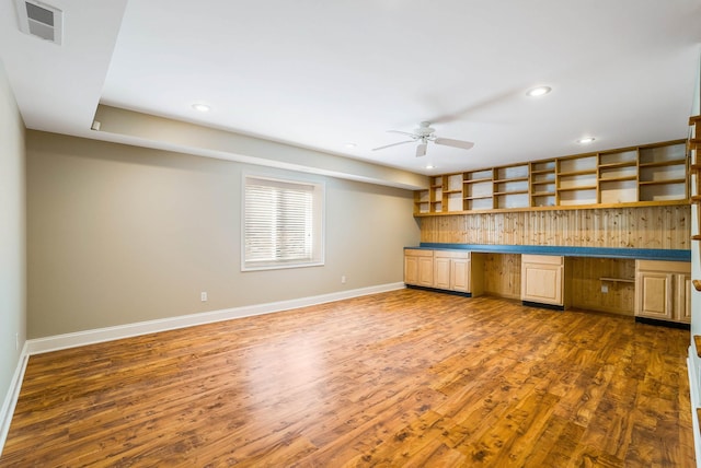 kitchen with built in desk, dark hardwood / wood-style floors, and ceiling fan