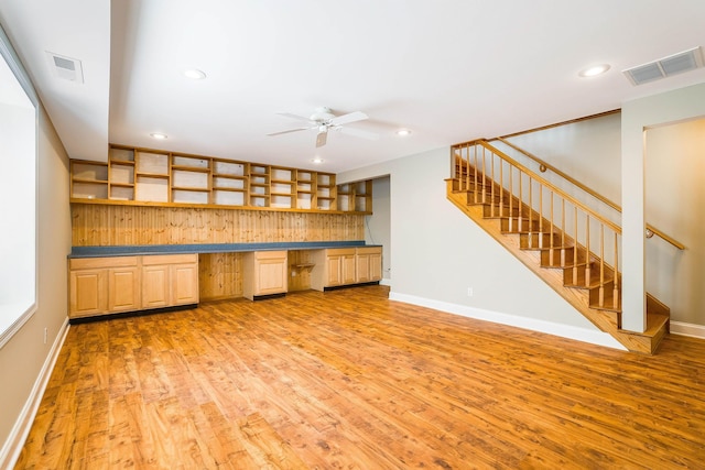 kitchen featuring ceiling fan, built in desk, and light hardwood / wood-style floors