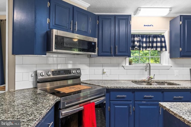 kitchen featuring a sink, appliances with stainless steel finishes, blue cabinetry, and a textured ceiling