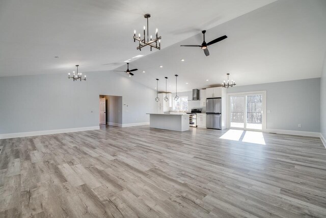 unfurnished living room featuring ceiling fan with notable chandelier, light hardwood / wood-style flooring, and high vaulted ceiling