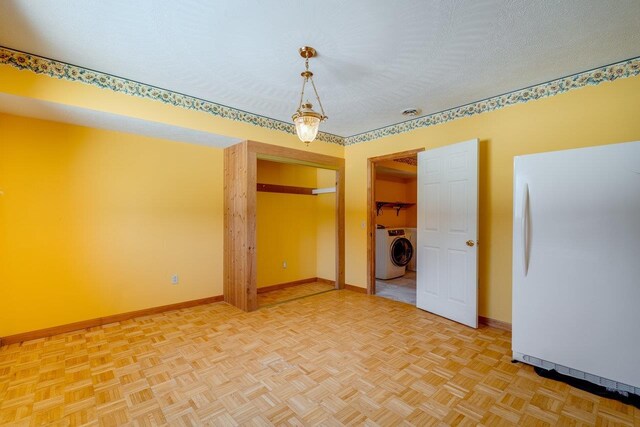 interior space with parquet floors, washer / clothes dryer, and a textured ceiling