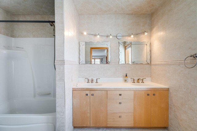 bathroom featuring vanity and tile walls