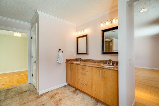 bathroom featuring ornamental molding, wood-type flooring, a textured ceiling, and vanity