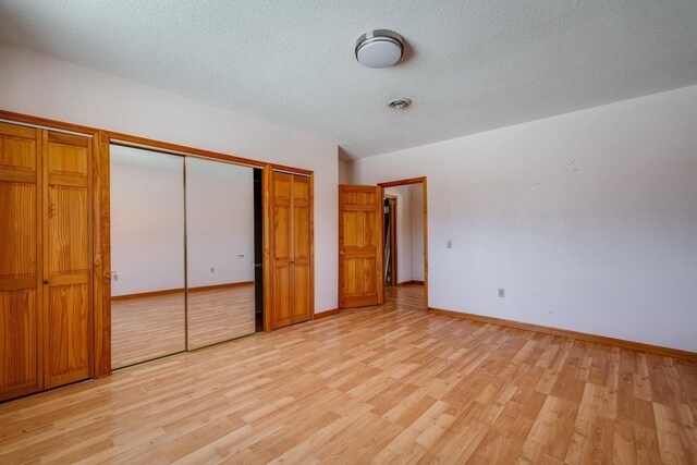 unfurnished bedroom featuring light hardwood / wood-style flooring and a textured ceiling