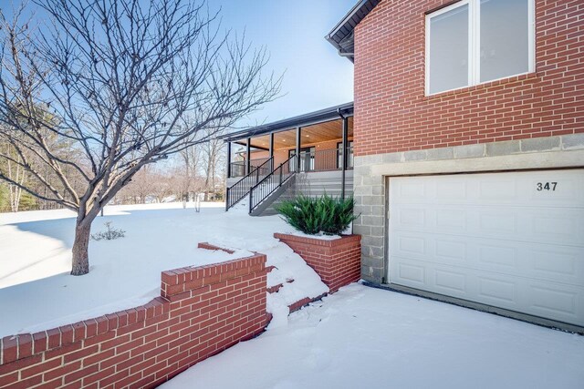 view of snow covered exterior with a garage