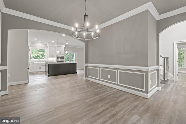 unfurnished dining area with crown molding, a wealth of natural light, and light hardwood / wood-style floors