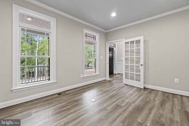 unfurnished room featuring crown molding, plenty of natural light, and light hardwood / wood-style flooring