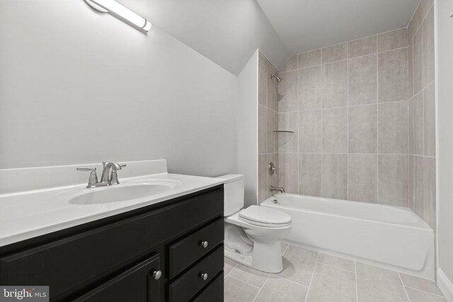 full bathroom featuring tiled shower / bath combo, vanity, tile patterned floors, and toilet