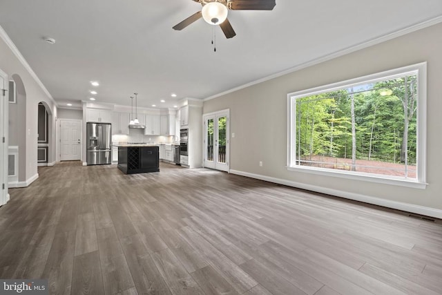 unfurnished living room featuring ornamental molding, hardwood / wood-style floors, and ceiling fan