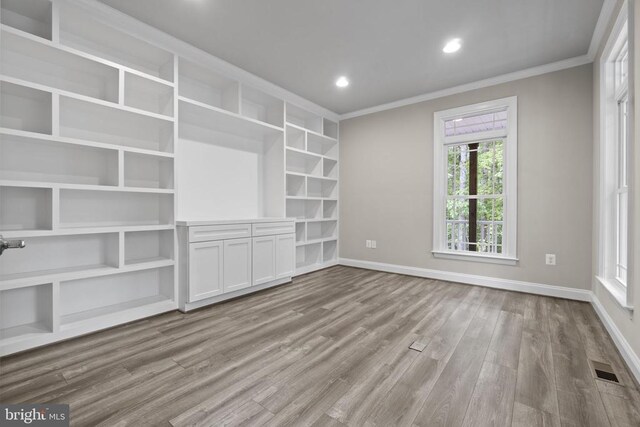 unfurnished living room featuring crown molding and light hardwood / wood-style floors