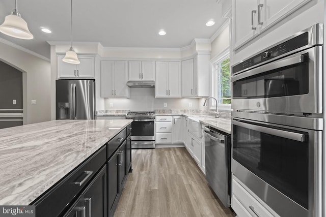 kitchen with decorative light fixtures, white cabinets, light hardwood / wood-style floors, stainless steel appliances, and crown molding