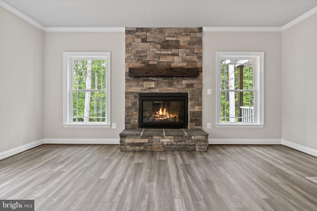 unfurnished living room featuring crown molding, a wealth of natural light, and light wood-type flooring