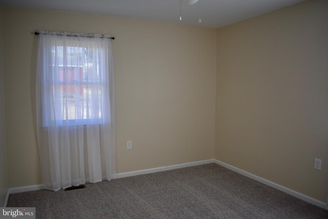 unfurnished room with carpet and baseboards